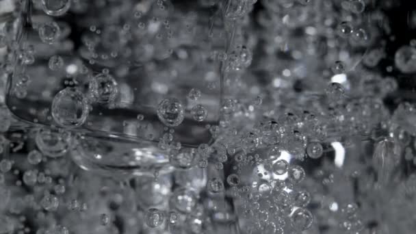 Filmagem de água mineral com bolhas em vidro — Vídeo de Stock