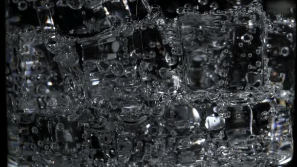 Macro shooting of soda water with bubbles in glass — Stock Video