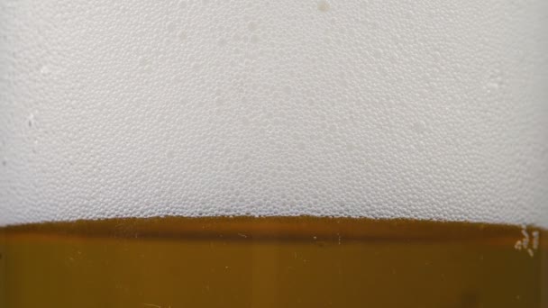 Images de bière d'or en verre avec mousse — Video