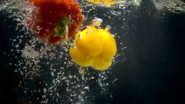 Siyah arka plan üzerine suya düşen biber görüntüleri