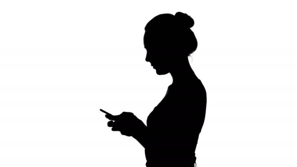 Silhouette adolescente con smartphone su sfondo bianco — Video Stock