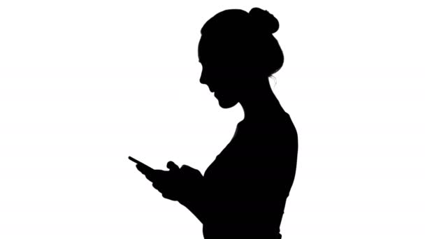 Silhouette adolescente avec smartphone sur fond blanc — Video