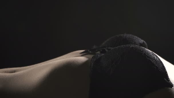 Видео лежащей сексуальной женщины в черном бюстгальтере — стоковое видео