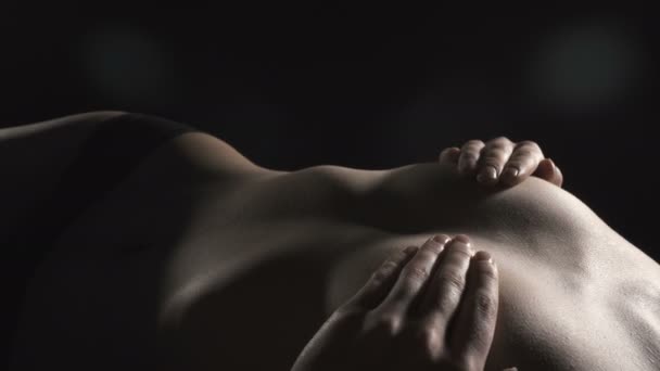 Видео лежащей девушки, прикрывающей грудь — стоковое видео