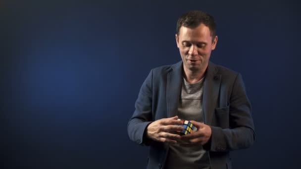Vídeo do homem ilusionista com cubo Rubiks — Vídeo de Stock