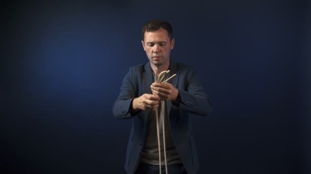 Hombre ilusionista con cuerdas marrones — Vídeo de stock