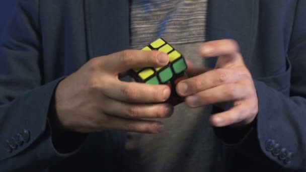 Střelba dospělého kouzelníka, který ukazuje trik s kostkou Rubiks — Stock video