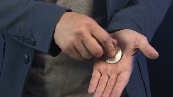 Исполнитель показывает трюк с монетами — стоковое видео