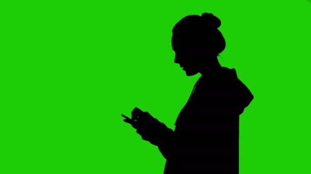 Puberťačky, silueta s smartphone na zeleném pozadí — Stock video