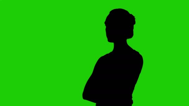 Meisjes half gedraaid silhouet met armen gekruist op groene achtergrond — Stockvideo