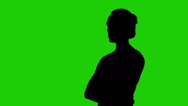 Womans half draaide silhouet met armen gekruist op groene achtergrond — Stockvideo