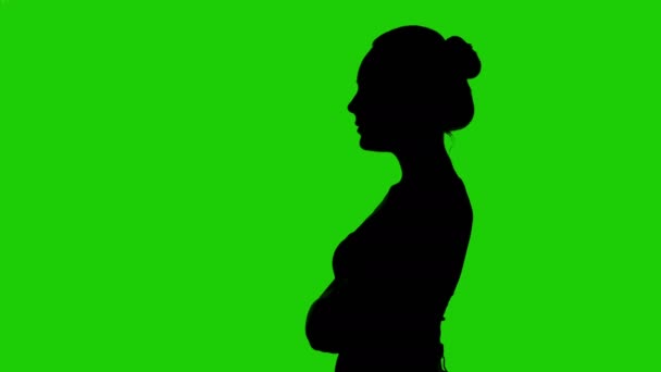 Womans silhouette in profile with arms crossed on green background — Stock Video