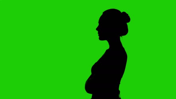 Girls silhouette in profile with arms crossed on green background — Stock Video