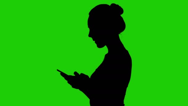 Teenage girls silhouette with smartphone on green background — Stock Video