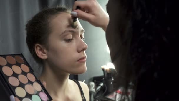 Tiro de visagista aplicando maquillaje de cimentación — Vídeos de Stock