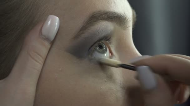 Visagista aplicando sombras de ojos en estudio de belleza — Vídeo de stock