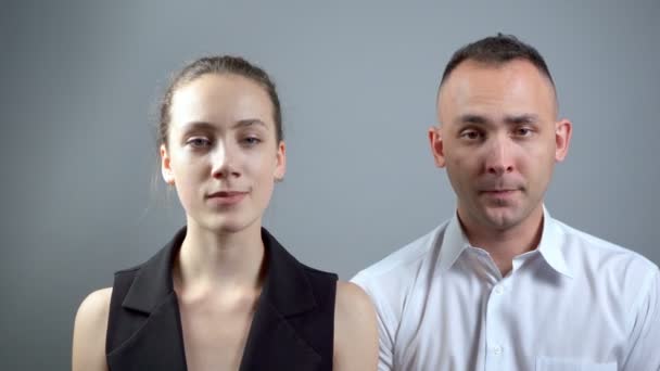 Zyklisches Video von Mann und Frau auf grauem Hintergrund — Stockvideo