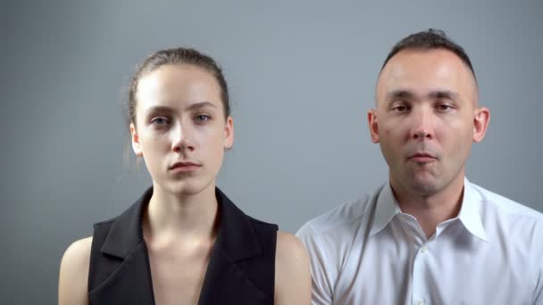 Video von zwei langweiligen Menschen auf grauem Hintergrund — Stockvideo