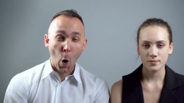 Gri arka planda eğlenceli ve grimacing adam Video