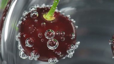 Bardakta olgun kiraz ve soda köpükleri.