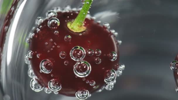 Cereza madura en vidrio con burbujas de agua de soda — Vídeos de Stock