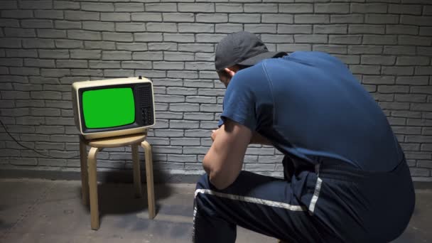 Зйомки чоловіка в кепці дивитися ретро телевізор — стокове відео