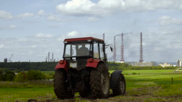 Video of tractor and industrial factory in the field — Stock Video