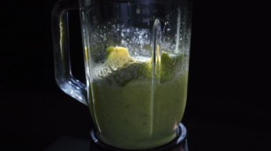 Siyah bir arka plan üzerinde bir blender sebze sallayarak Video
