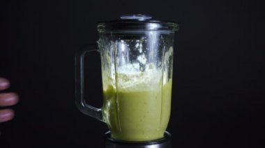 Siyah bir arka plan üzerinde bir blender diyet sebze yüzlü Pişirme