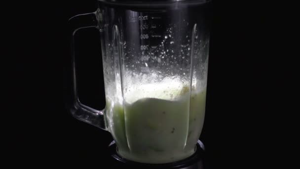 Secouer les légumes diététiques dans un mélangeur sur un fond noir — Video