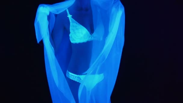 Video einer Frau in weißen Dessous im ultravioletten Licht — Stockvideo