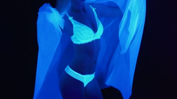 Slanke vrouw in witte lingerie in ultraviolet licht — Stockvideo