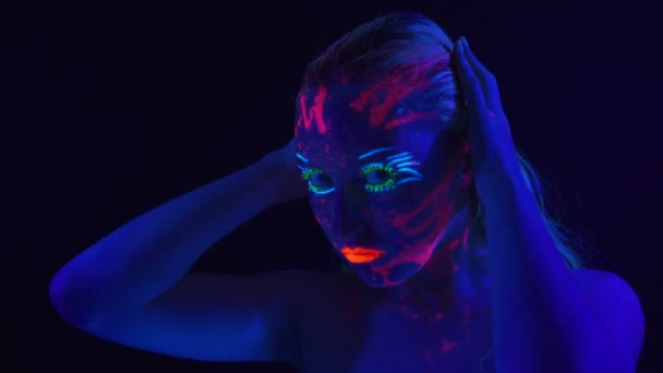 Young woman with bright bodyart in ultraviolet light — Stock Video