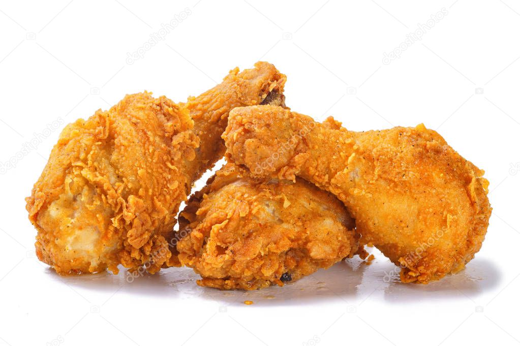 Fried yellow crispy spicy chicken legs on white background