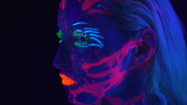 Видео молодой женщины с ярким телом в ультрафиолетовом свете — стоковое видео