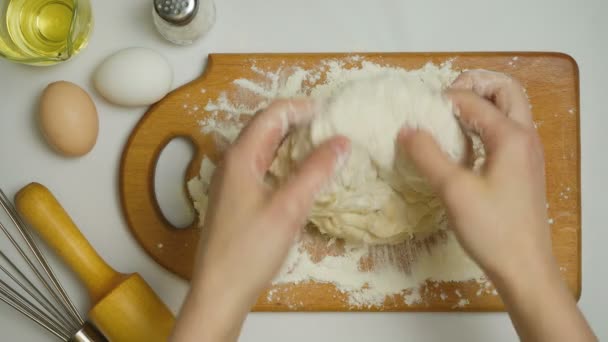 Видео, как женщина ковыляет тесто в доме — стоковое видео