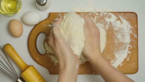 Видео, как девочка ковыляет тесто в доме — стоковое видео