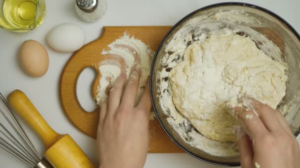 Видео, как девочка ковыляет тесто на кухне — стоковое видео