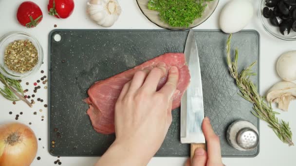 Video van het snijden van varkensvlees plakjes in de keuken — Stockvideo