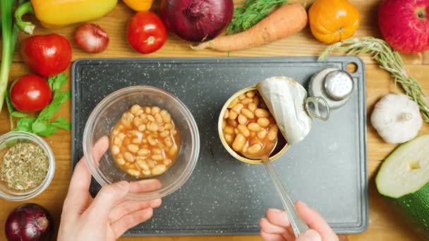 Mujer abre lata con frijoles, vista superior — Vídeo de stock