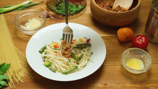 Відео вручну приготування макаронних виробів з овочами на кухні — стокове відео