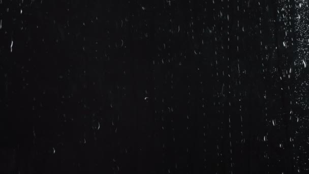 Water druppels op zwarte glazen oppervlak — Stockvideo