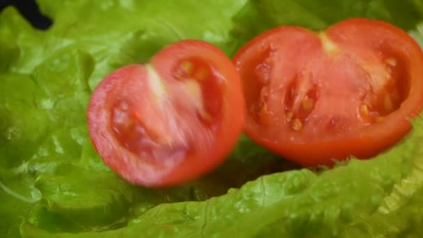 Video van vallende halve tomaat op ijsbergsalade — Stockvideo