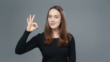 Siyah tişörtlü genç kızın iyi bir jest yaptığı bir video.