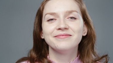Pembe balıkçı yaka kazaklı, gülümseyen kadının videosu.
