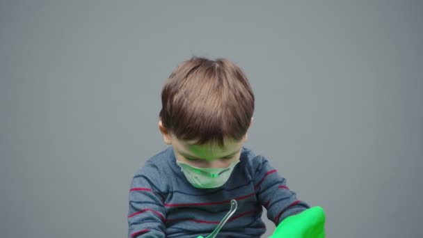 Liten fyraårig pojke i skyddsmask, handskar och glasögon — Stockvideo