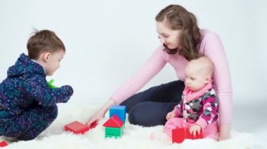 Anne ve çocukları oynuyorlar, kule inşa ediyorlar.