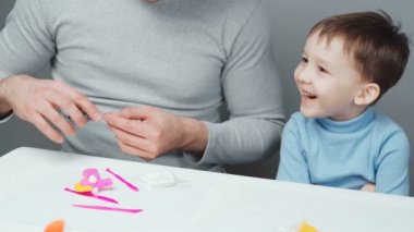 Baba ve oğul plastik oyuncaklar yontuyorlar.