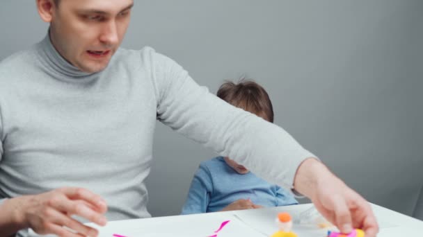 Disparos de padre e hijo esculpiendo juguetes de plastilina — Vídeos de Stock