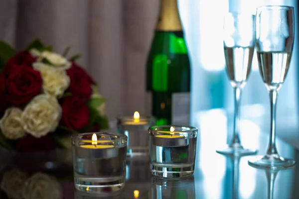 Фотошампанское со свечами на тумбочке — стоковое фото